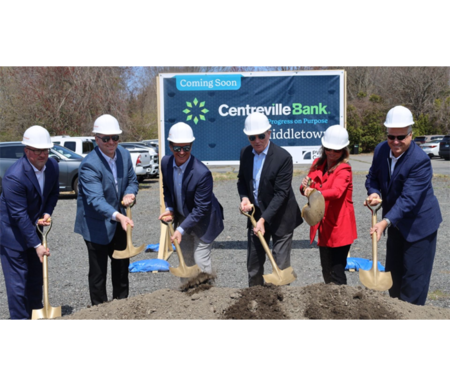 Six people in hard hats using gold shovels to dig into dirt for a Centreville Bank groundbreaking.