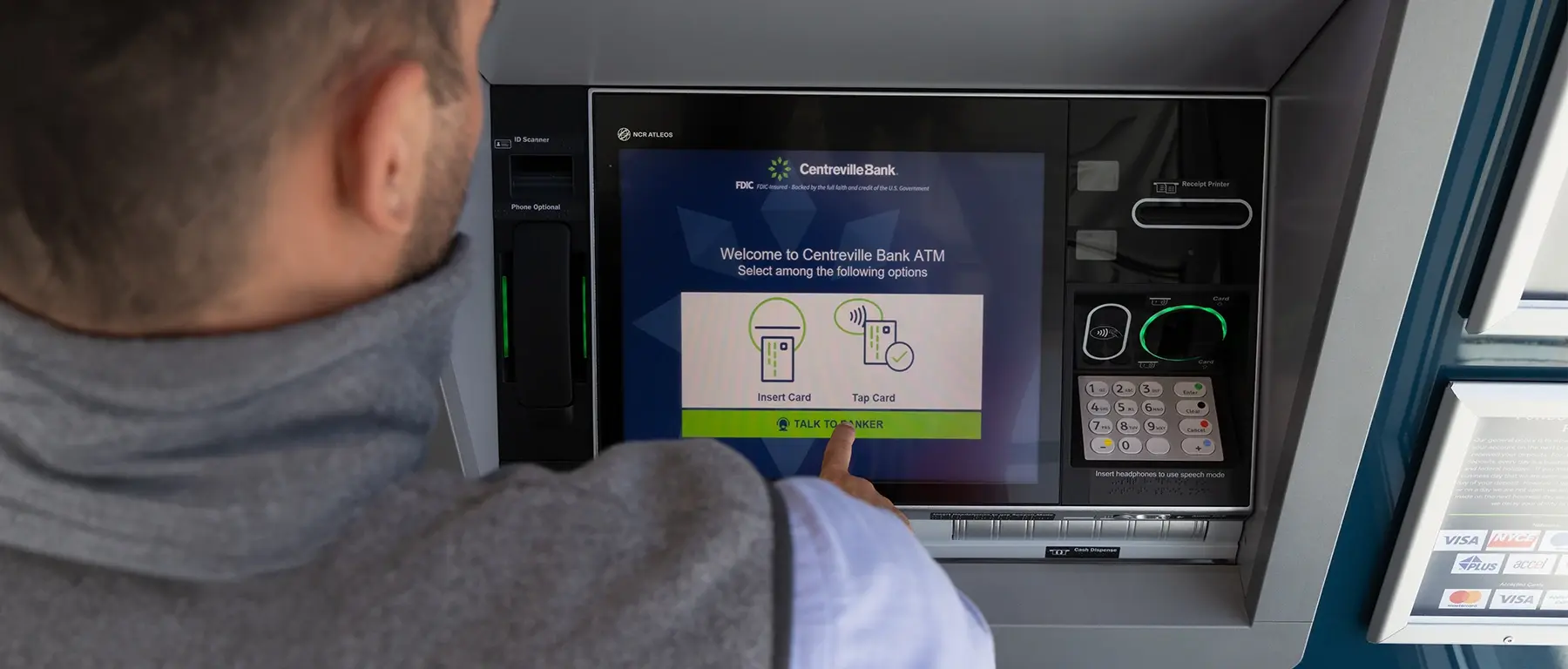 A customer touches the welcome screen of an outdoor Centreville Bank interactive teller machine
