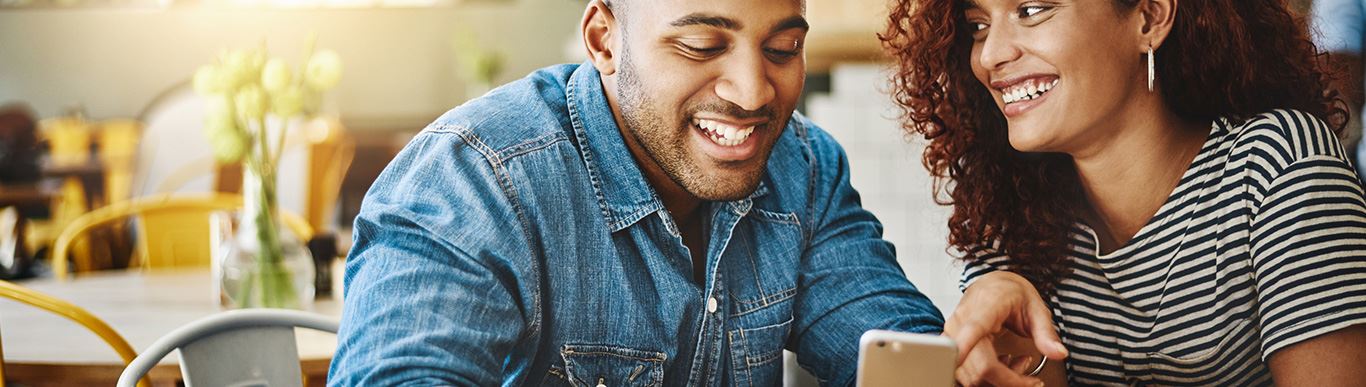 couple laughing and looking at their phone