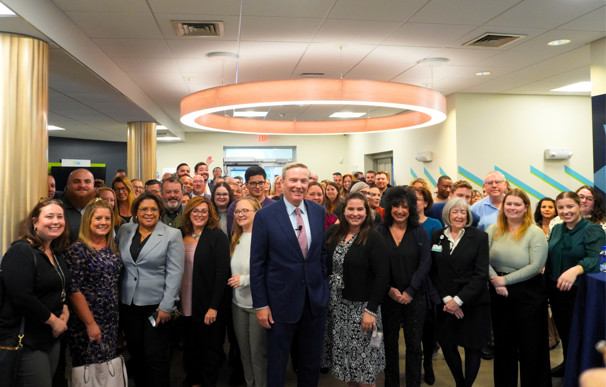 A large group of Centreville Bank employees gathered together indoors for a group photograph
