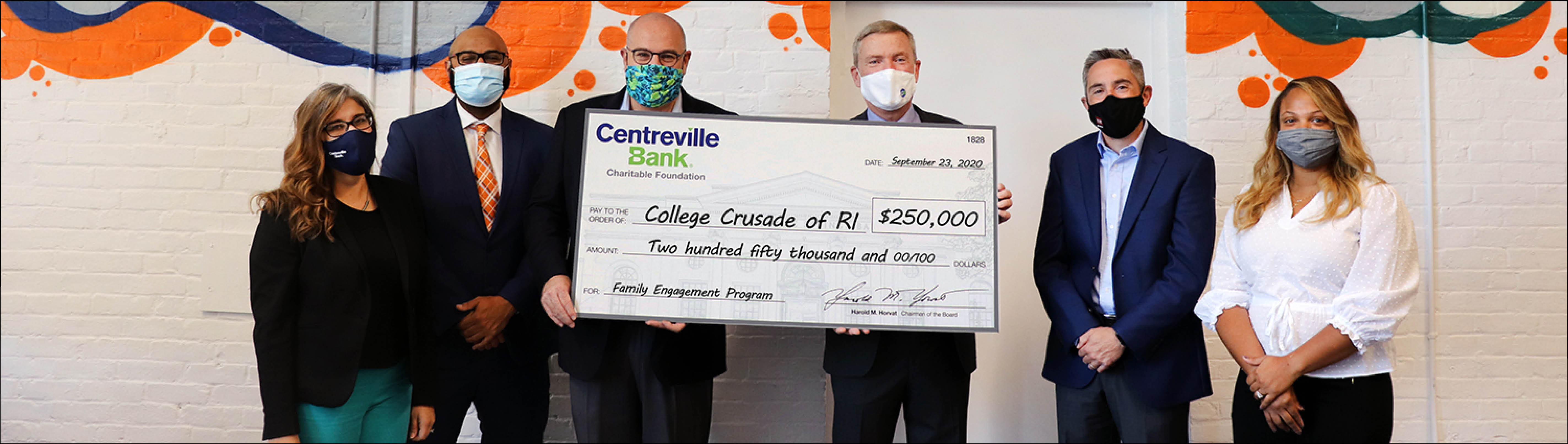 Six people in masks hold an oversized Centreville Bank Charitable Foundation check for $250,000 to College Crusade of RI
