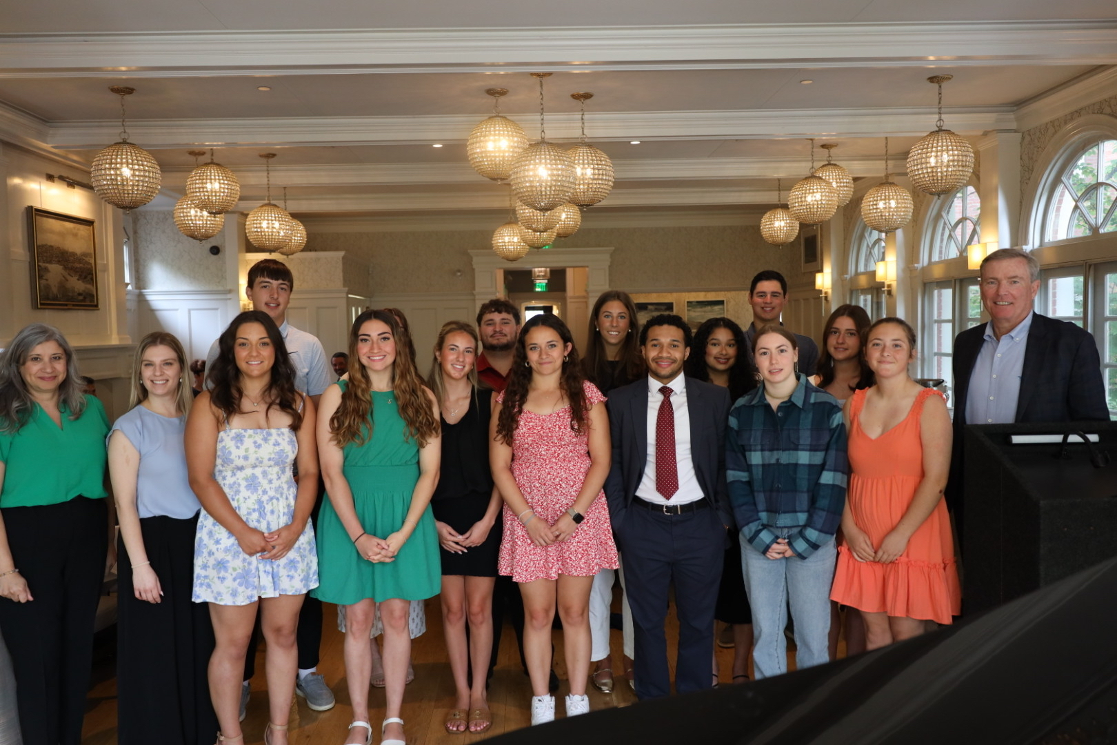 A group of scholarship recipients pose together in a function room at an awards ceremony